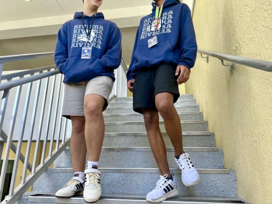 Two students (Manuel Valcarcel and Esteban Chiquito) walking down the stairs wearing their Riviera Hoodies. 