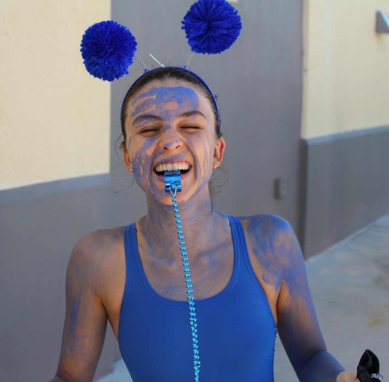 Junior Maria Bezerra embraces her team spirit in complete blue apparel and paint, or like she said “dressing like a smurf.” 
