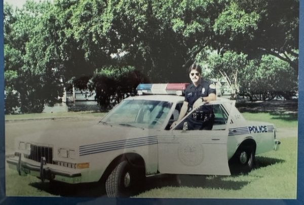 George Gulla stands beside his patrol car in 1990 when he was a young patrol officer.