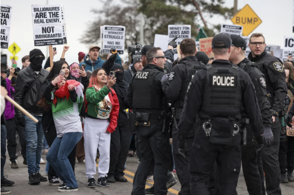 Police officers stand between demonstrators and traffic during a protest over immigration enforcement in Minnesota. 
